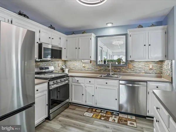 a kitchen with granite countertop a refrigerator stove and sink