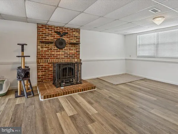 a room with a center island a dining table wooden floor and a clock