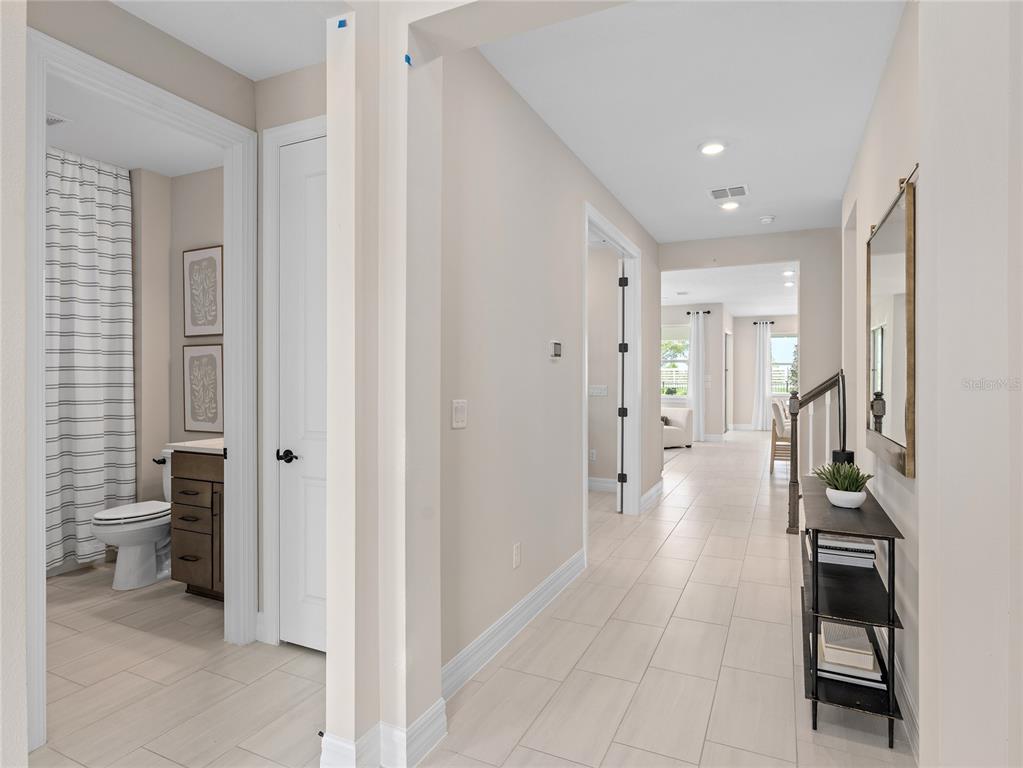 5624 Flame Vine Way St. Cloud, FL 34771 - Photo 4 of 29 a view of a hallway with wooden floor and a bathroom
