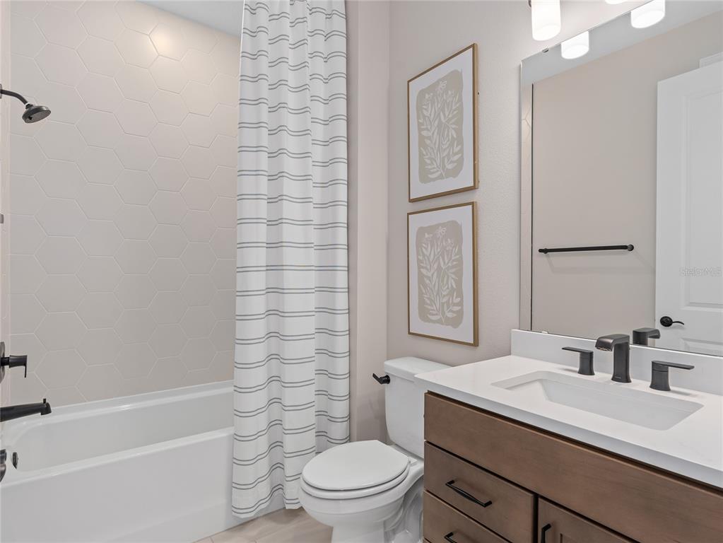 5624 Flame Vine Way St. Cloud, FL 34771 - Photo 7 of 29 a bathroom with a sink a toilet and shower