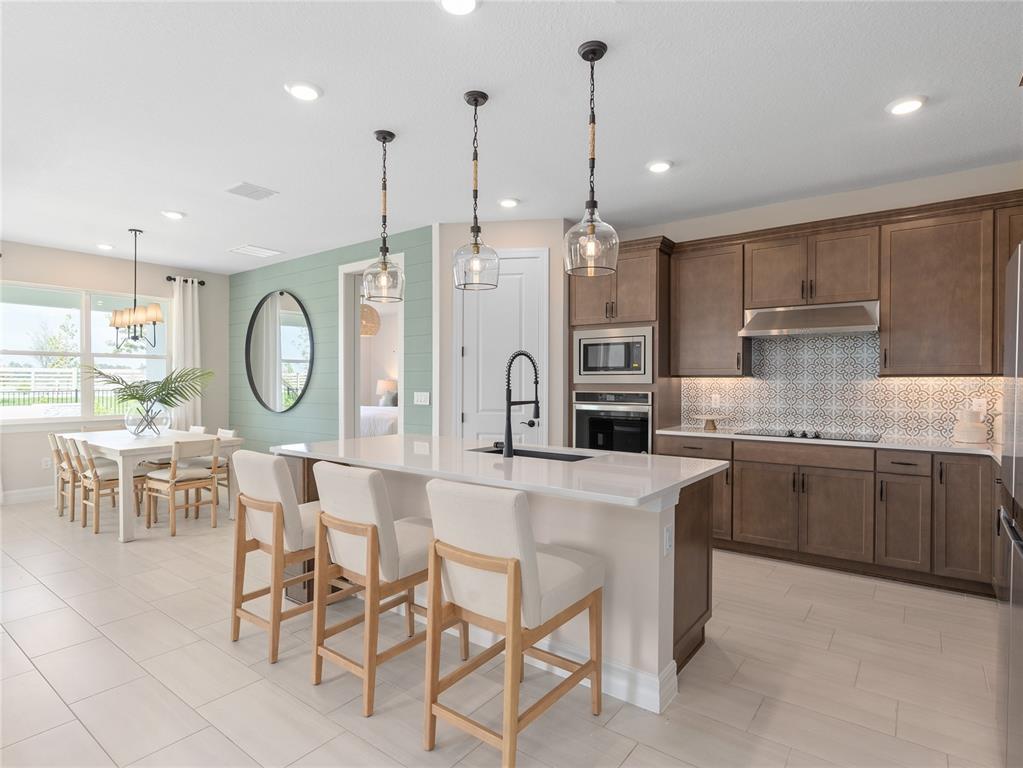 5624 Flame Vine Way St. Cloud, FL 34771 - Photo 10 of 29 a large kitchen with a table and chairs