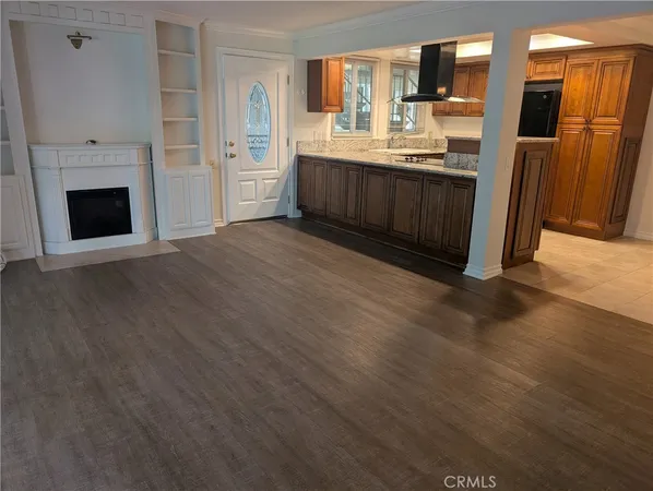 a large kitchen with cabinets wooden floor and a fireplace