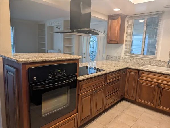 a kitchen with granite countertop a stove sink and cabinets