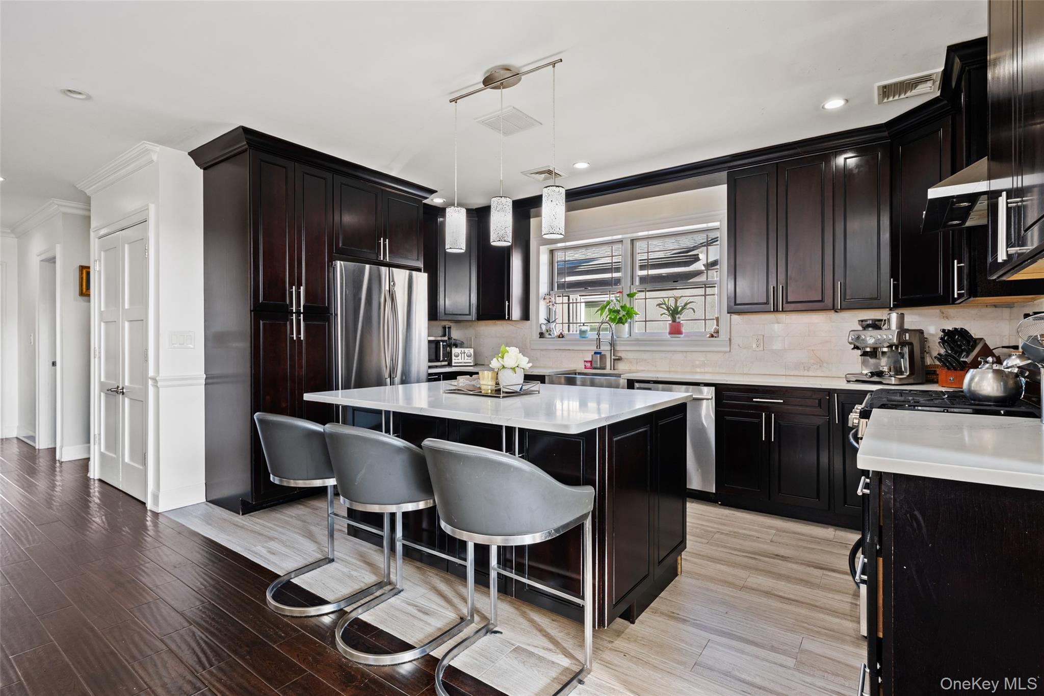2063 Narragansett Avenue, Unit 2 Bronx, NY 10461 - Photo 13 of 37 Kitchen featuring a kitchen bar, tasteful backsplash, pendant lighting, a center island, and light wood-style flooring