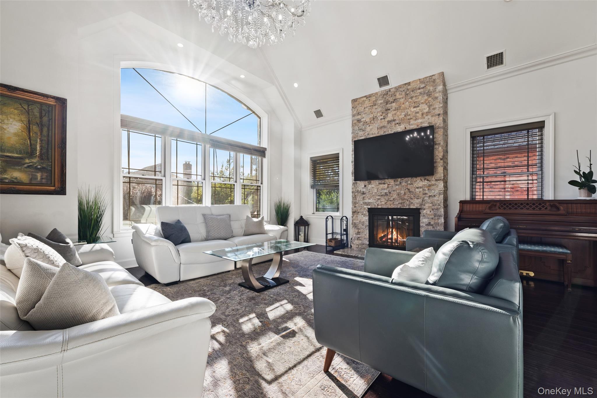 2063 Narragansett Avenue, Unit 2 Bronx, NY 10461 - Photo 2 of 37 Living room with high vaulted ceiling, a stone fireplace, a chandelier, crown molding, and recessed lighting