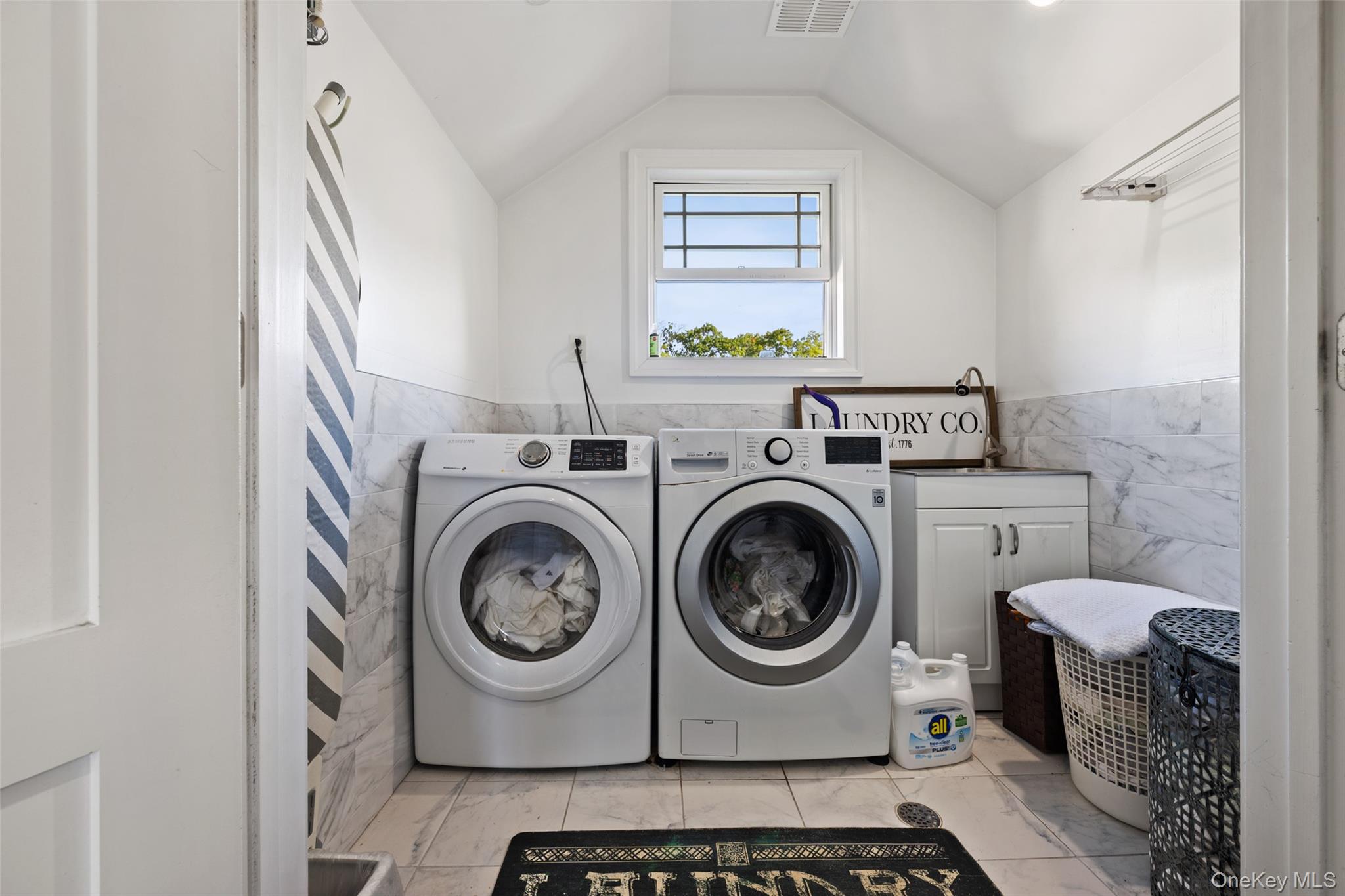 2063 Narragansett Avenue, Unit 2 Bronx, NY 10461 - Photo 21 of 37 Laundry area with tile walls, a wainscoted wall, and independent washer and dryer