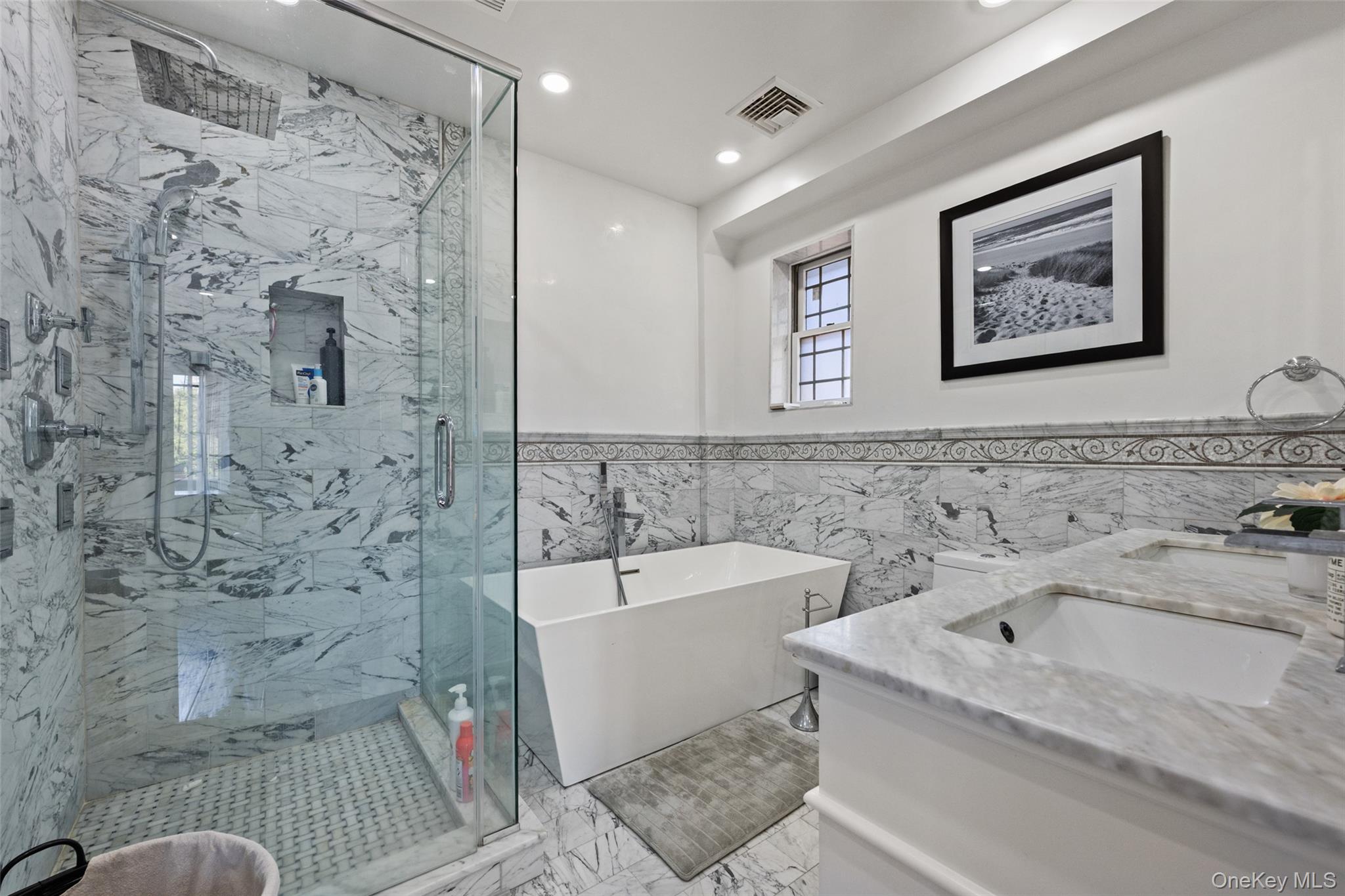 2063 Narragansett Avenue, Unit 2 Bronx, NY 10461 - Photo 5 of 37 Full bath with tile walls, a freestanding tub, double vanity, a marble finish shower, and wainscoting
