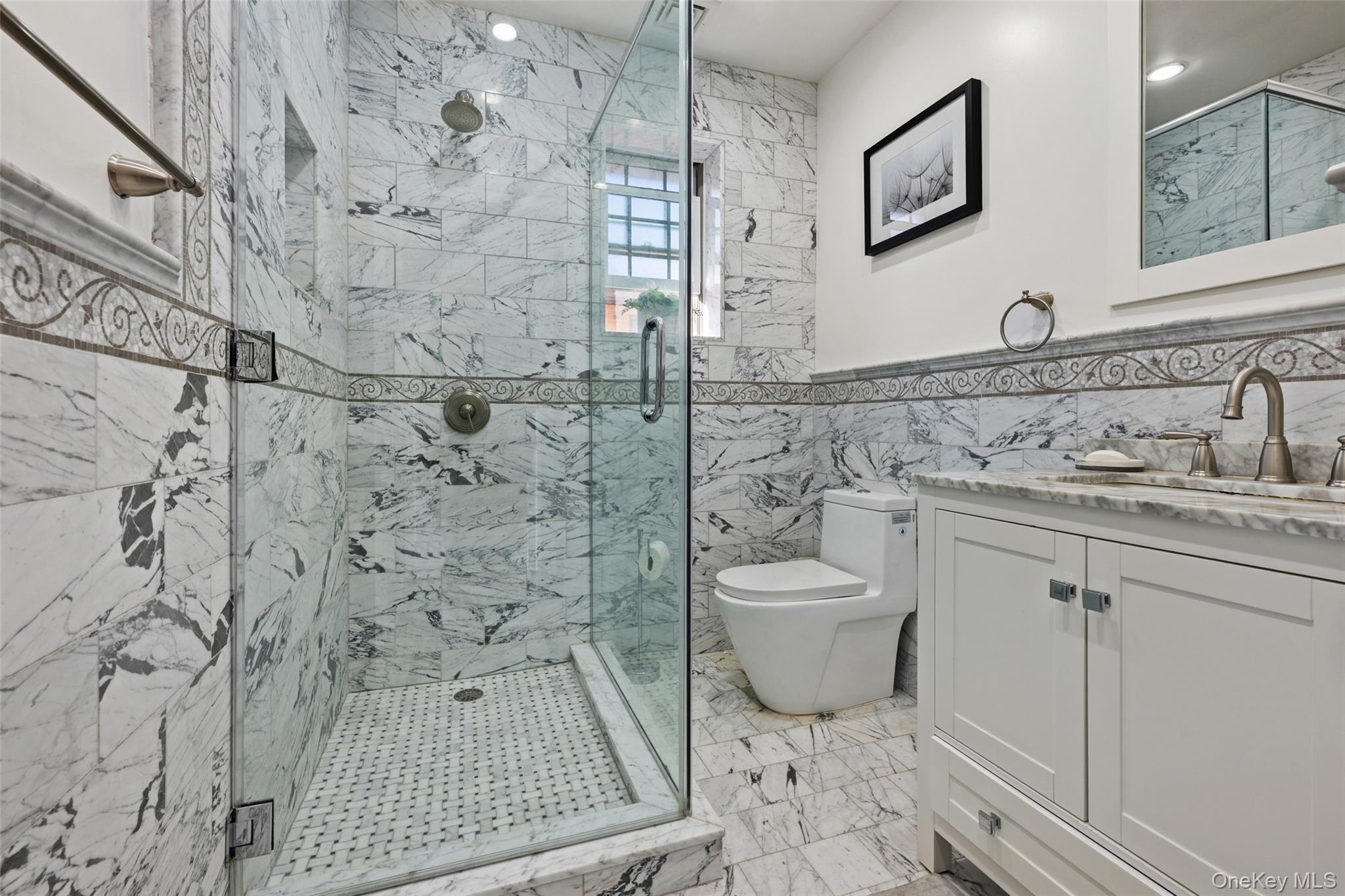 2063 Narragansett Avenue, Unit 2 Bronx, NY 10461 - Photo 10 of 37 Bathroom featuring tile walls, a marble finish shower, vanity, and light marble finish floors