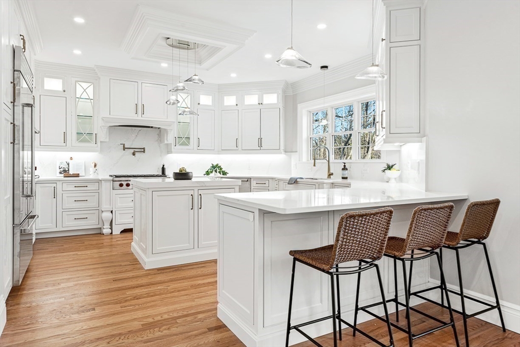 7 Crossman Road Woburn, MA 01801 - Photo 13 of 42 a kitchen with kitchen island granite countertop a sink cabinets and wooden floor