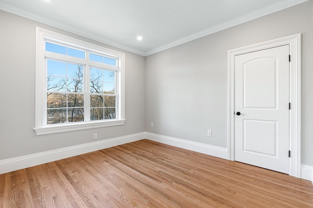 7 Crossman Road Woburn, MA 01801 - Photo 18 of 42 a view of an empty room with wooden floor and a window