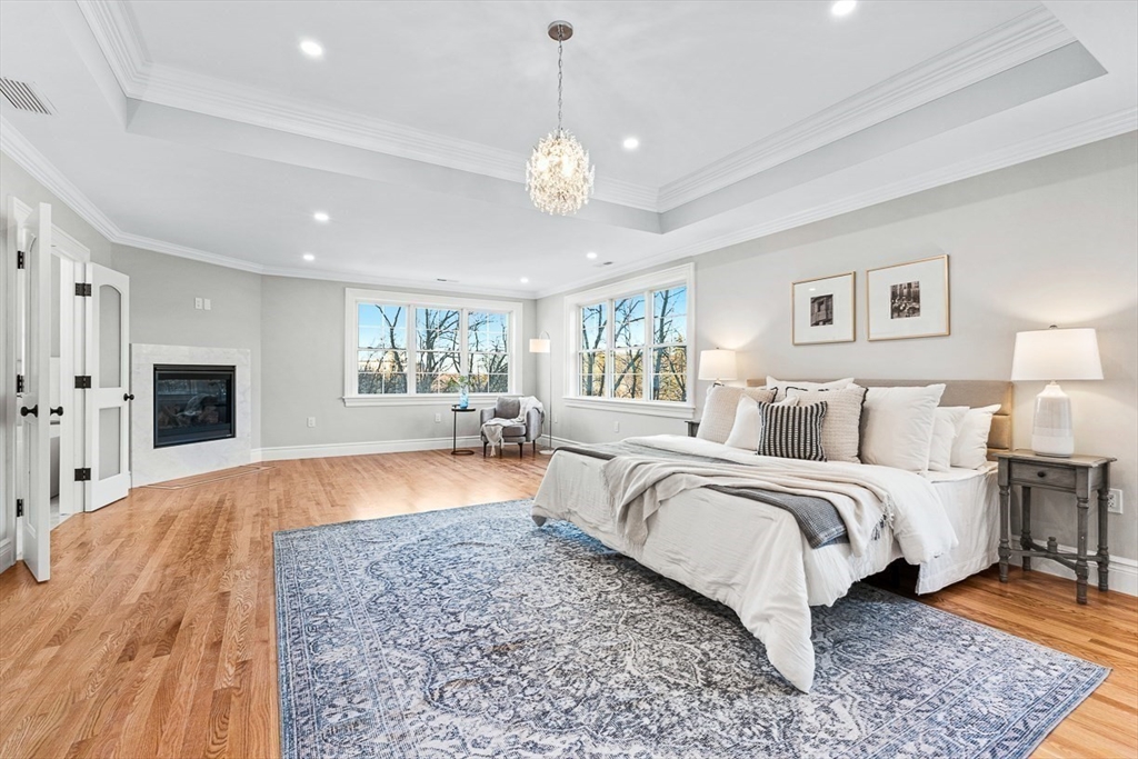 7 Crossman Road Woburn, MA 01801 - Photo 26 of 42 a spacious bedroom with a large bed and a chandelier