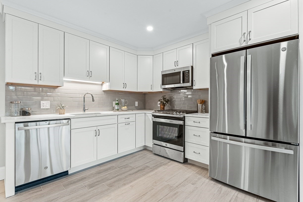 7 Crossman Road Woburn, MA 01801 - Photo 32 of 42 a kitchen with granite countertop white cabinets and stainless steel appliances