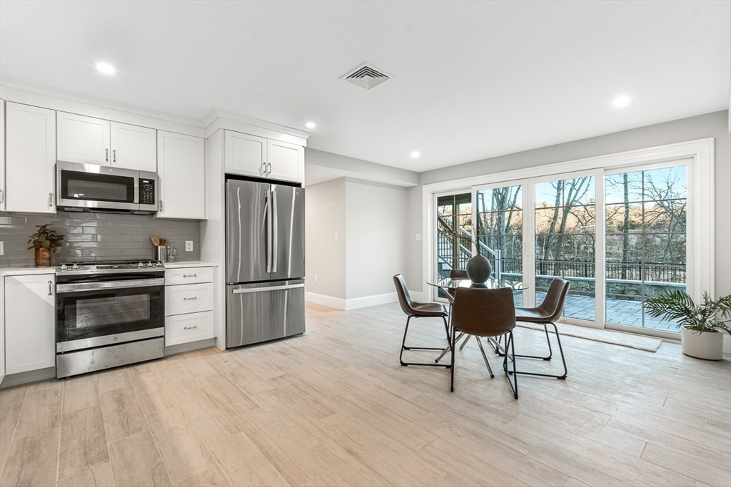 7 Crossman Road Woburn, MA 01801 - Photo 33 of 42 a kitchen with a table chairs refrigerator and microwave