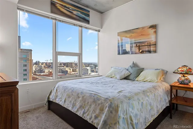 a bedroom with a bed and a large window