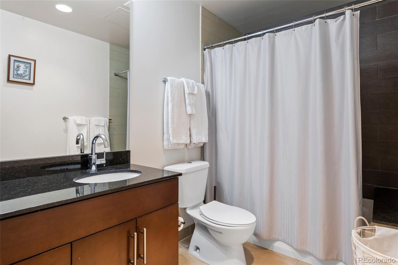 891 14th Street, Unit 1916 Denver, CO 80202 - Photo 17 of 33 a bathroom with a sink a toilet and shower curtain