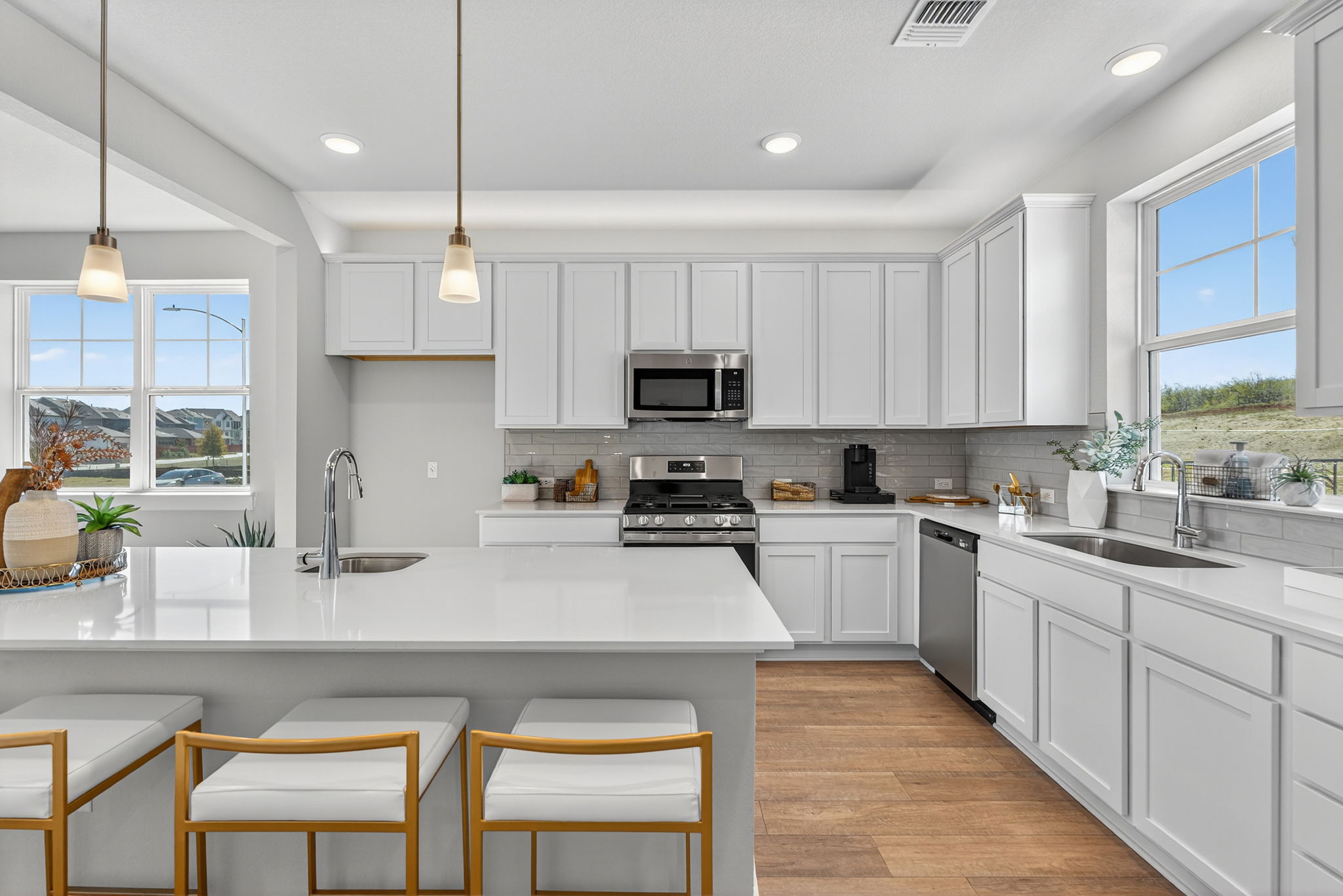5904 Rotunda View Austin, TX 78747 - Photo 5 of 37 Kitchen featuring white cabinets, tasteful backsplash, hanging light fixtures, light stone countertops, and recessed lighting