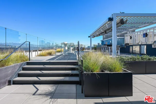 a view of swimming pool with seating area and trees in the background