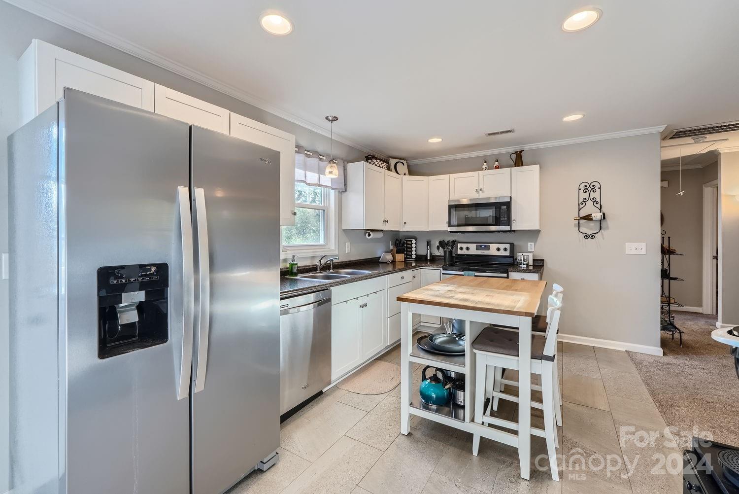 11111 Graybark Road Midland, NC 28107 - Photo 12 of 37 a kitchen with granite countertop a refrigerator and a stove top oven