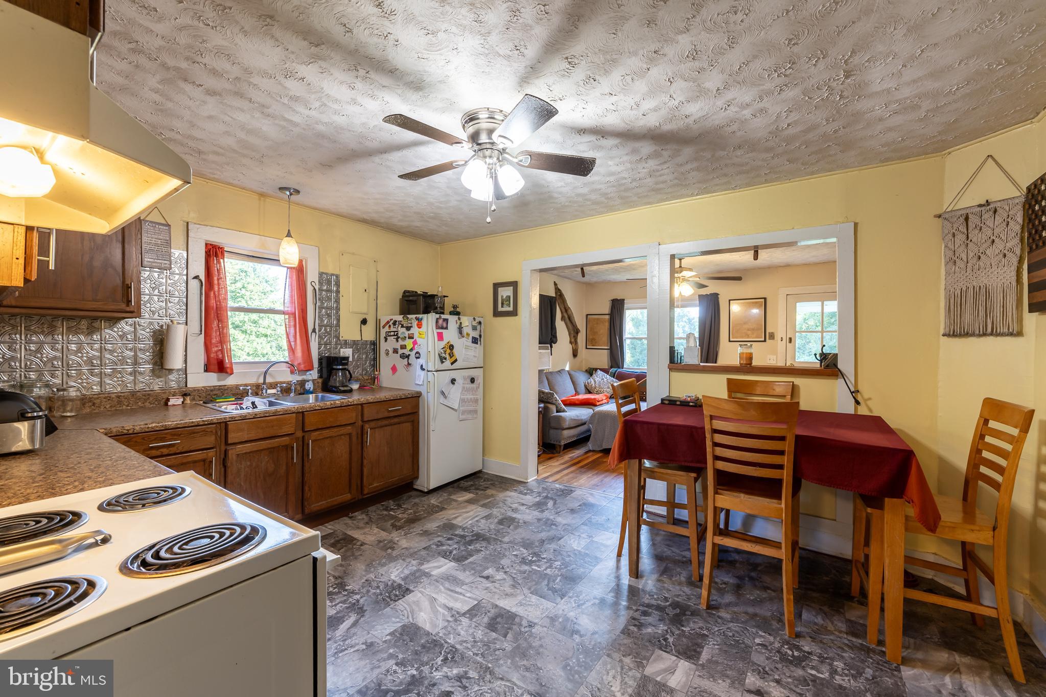 17227 Oakshade Road Orange, VA 22960 - Photo 4 of 19 a kitchen with a dining table chairs and white appliances