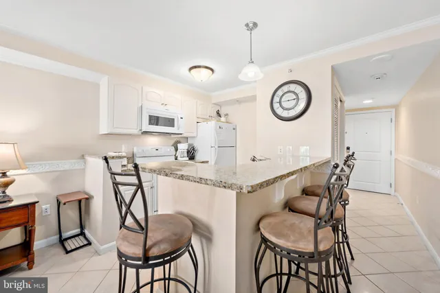 a kitchen with granite countertop white cabinets and white appliances