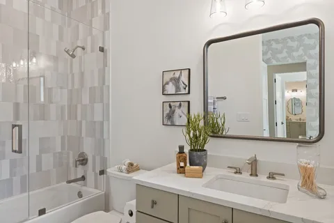 a spacious bathroom with a double vanity sink a large mirror and a bathtub