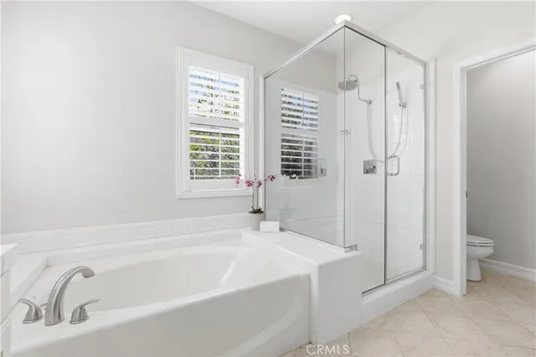 a bathroom with a double vanity sink toilet mirror and bathtub