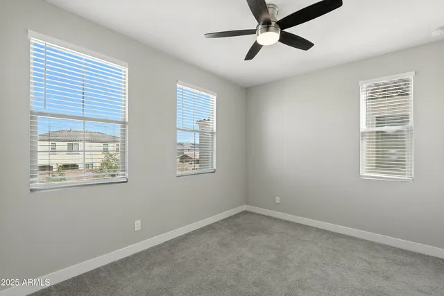 an empty room with closet and a ceiling fan