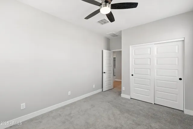 an empty room with closet and windows