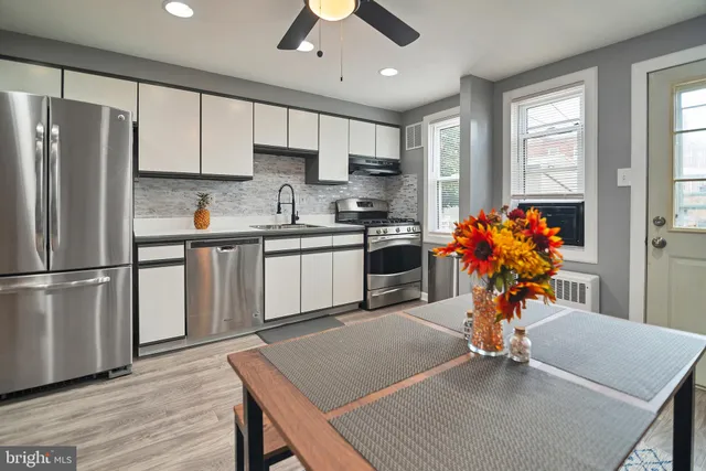 a kitchen with stainless steel appliances granite countertop a refrigerator a sink dishwasher a stove and a refrigerator with wooden floor