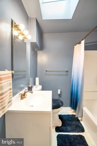 a bathroom with a sink a toilet and a mirror