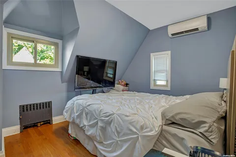 a bedroom with a bed flat screen tv and a window