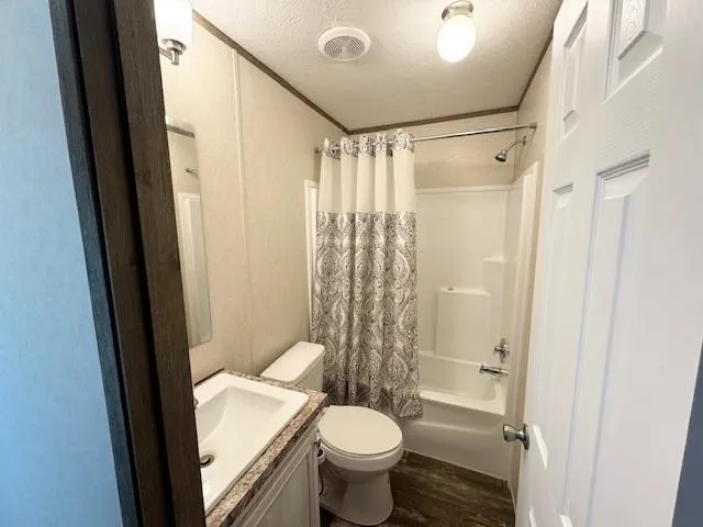 a bathroom with a granite countertop toilet a sink and a mirror