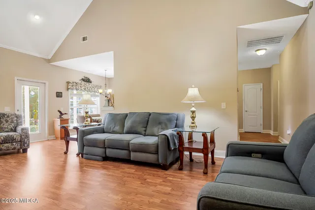 a kitchen with stainless steel appliances granite countertop a stove a sink and a refrigerator with wooden floor