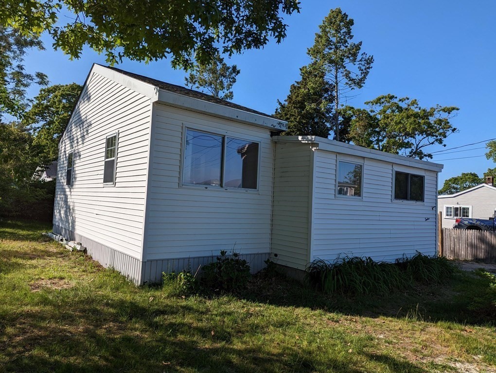 a view of house with backyard and outdoor seating