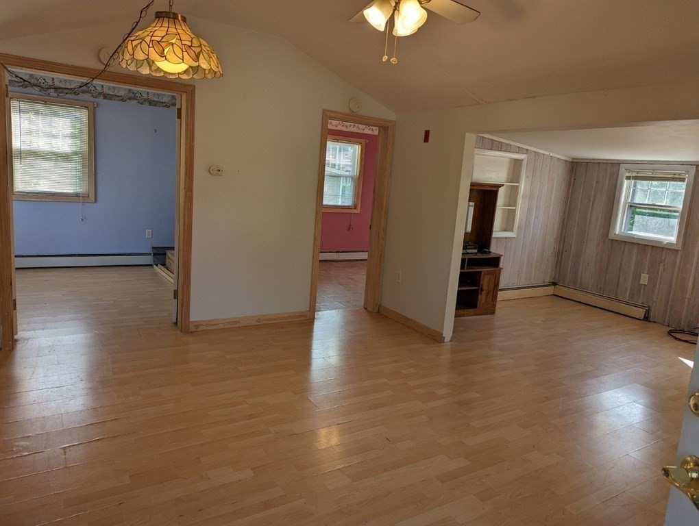 12 Howard Street Wareham, MA 02571 - Photo 3 of 11 an empty room with wooden floor chandelier and windows