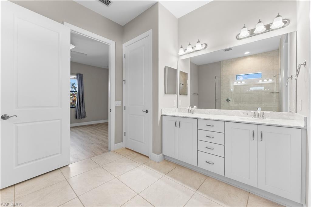 4711 Abaca Circle Naples, FL 34119 - Photo 17 of 32 a spacious bathroom with a granite countertop sink mirror and shower