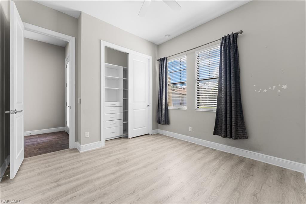 4711 Abaca Circle Naples, FL 34119 - Photo 19 of 32 an empty room with wooden floor closet and windows