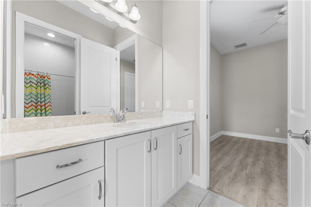 4711 Abaca Circle Naples, FL 34119 - Photo 20 of 32 a bathroom with a granite countertop sink and a mirror
