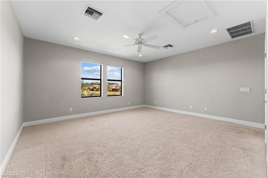 4711 Abaca Circle Naples, FL 34119 - Photo 22 of 32 an empty room with windows and ceiling fan
