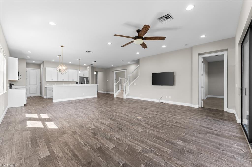 4711 Abaca Circle Naples, FL 34119 - Photo 5 of 32 a view of an empty room and kitchen with wooden floor