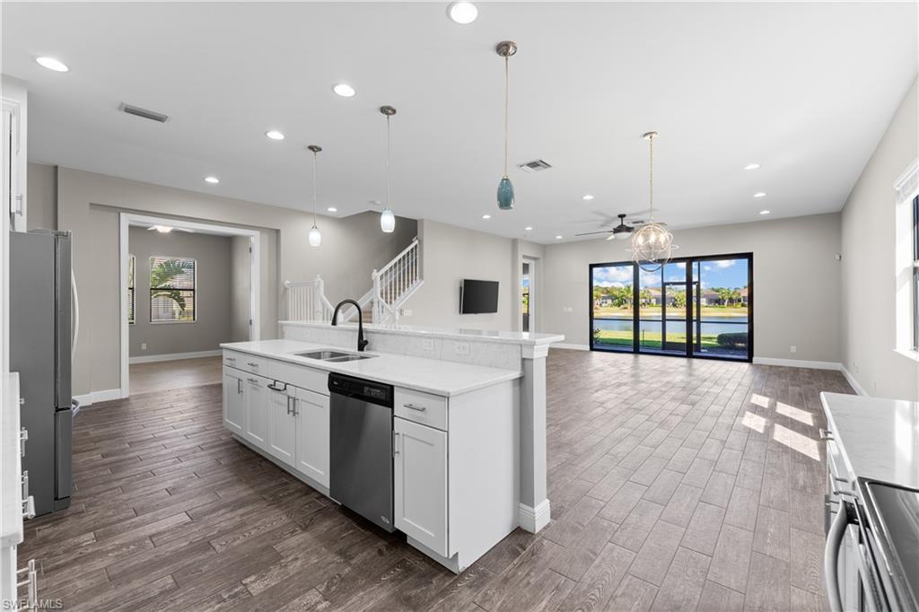 4711 Abaca Circle Naples, FL 34119 - Photo 6 of 32 a large kitchen with stainless steel appliances kitchen island a large counter top and a wooden floors