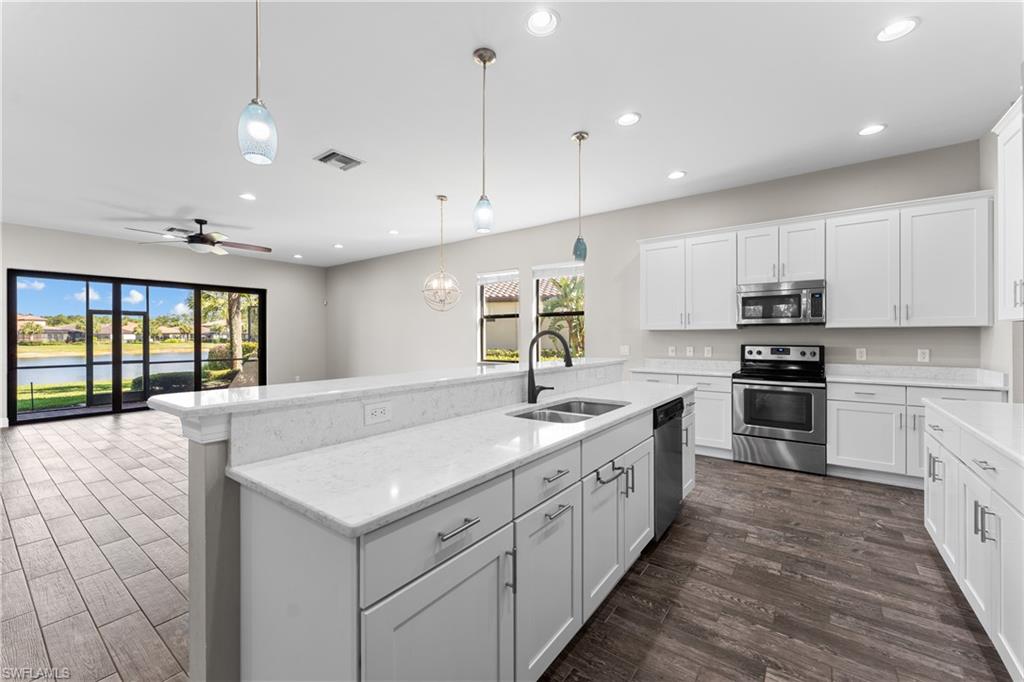 4711 Abaca Circle Naples, FL 34119 - Photo 8 of 32 a large kitchen with kitchen island a sink stainless steel appliances and cabinets
