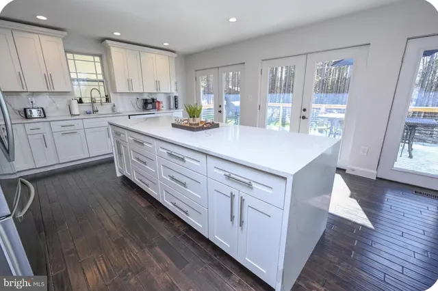 a kitchen with white cabinets and white appliances