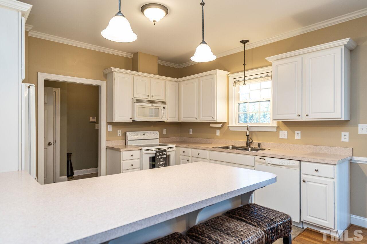 4131 Pearces Road Zebulon, NC 27597 - Photo 12 of 31 a kitchen with a stove a sink a center island and cabinets