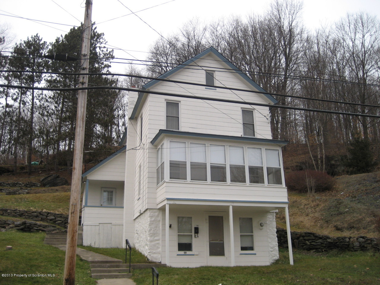 a view of a white house with large windows and a small yard