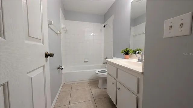 a front view of a house with a yard and potted plants