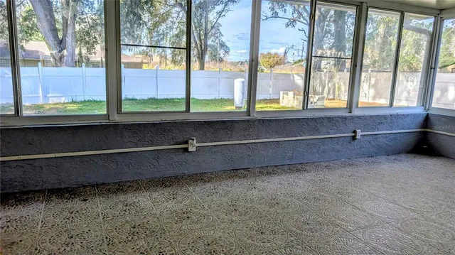 an empty room with windows and fireplace