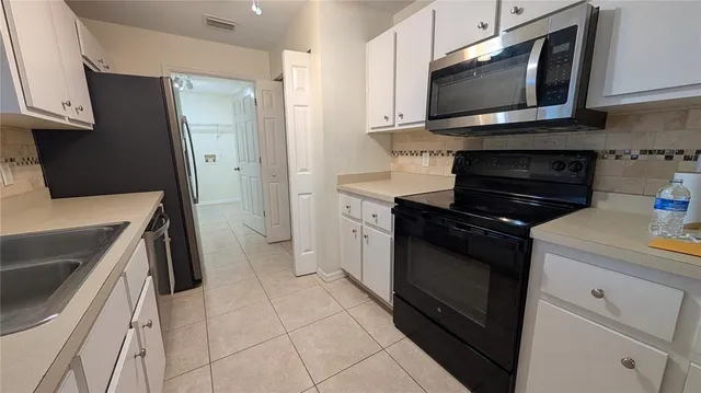 a kitchen with a sink cabinets and stainless steel appliances
