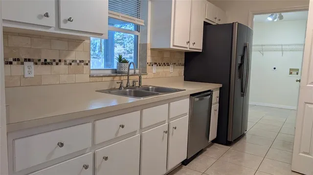 a kitchen with a sink a refrigerator and cabinets