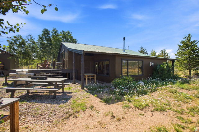 1663 Lancer Lane Evanston, UT 82930 - Photo 25 of 101 Wood-sided residence featuring a covered porch, metal roof, and multiple large windows